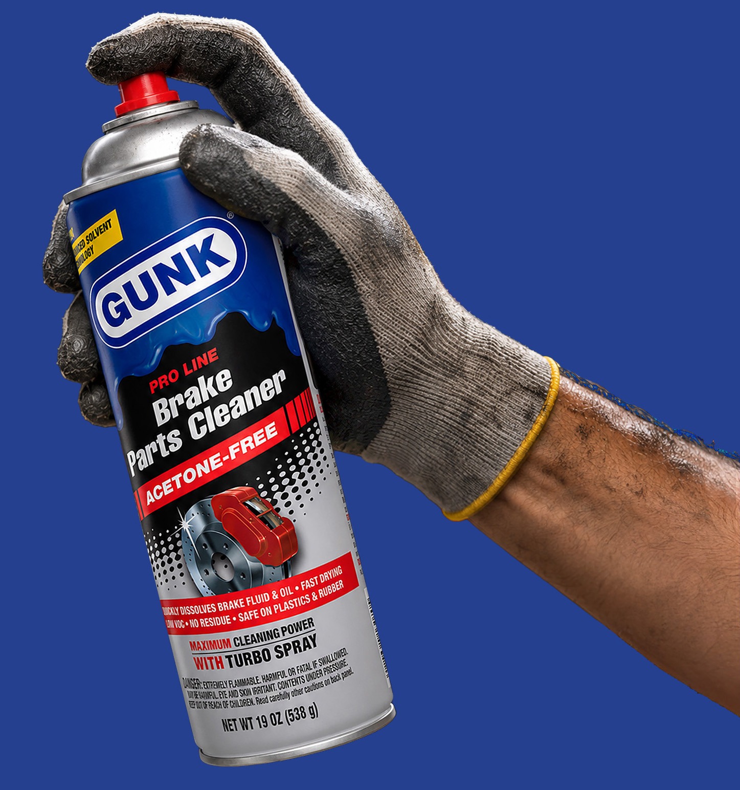 Auto mechanic spraying brake fluid on wheel disk in garage